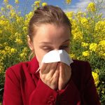 woman-sneezing-into-tissue-near-plants
