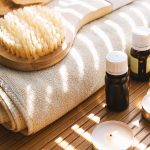 dry skin brush on towel with essential oils and candles