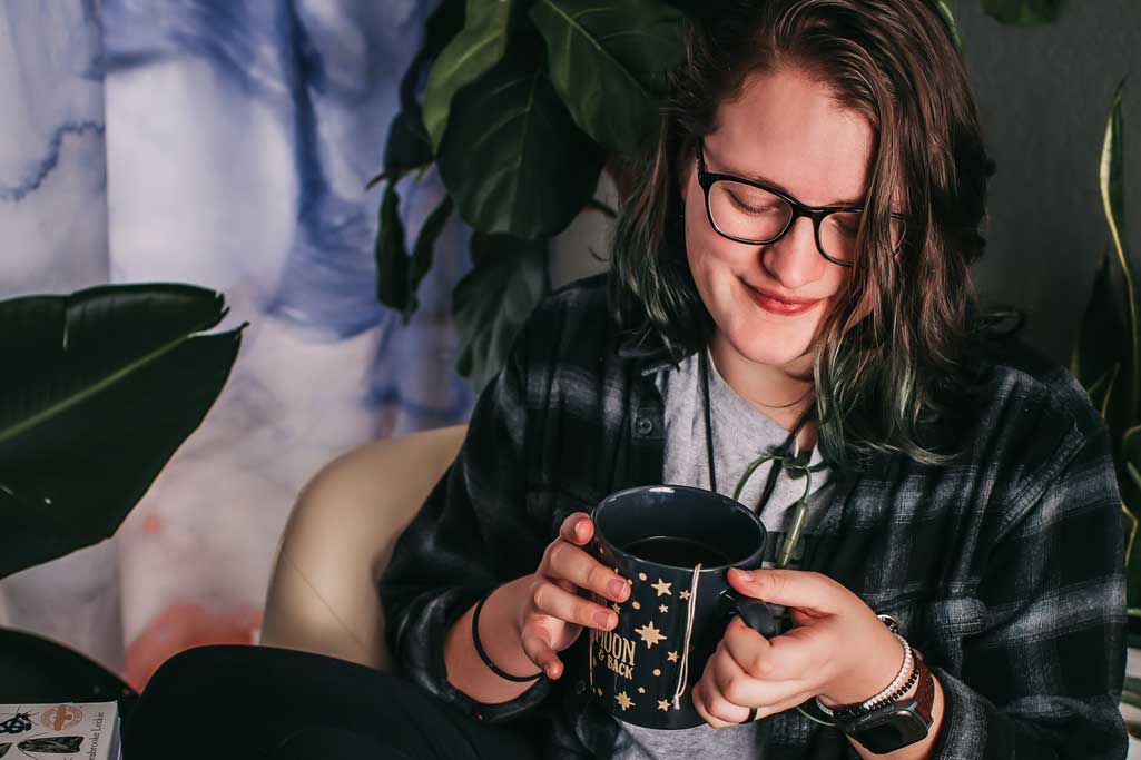 Cade-Birge-Sitting-on-Chair-with-Cup-in-Hands-Looking-Down