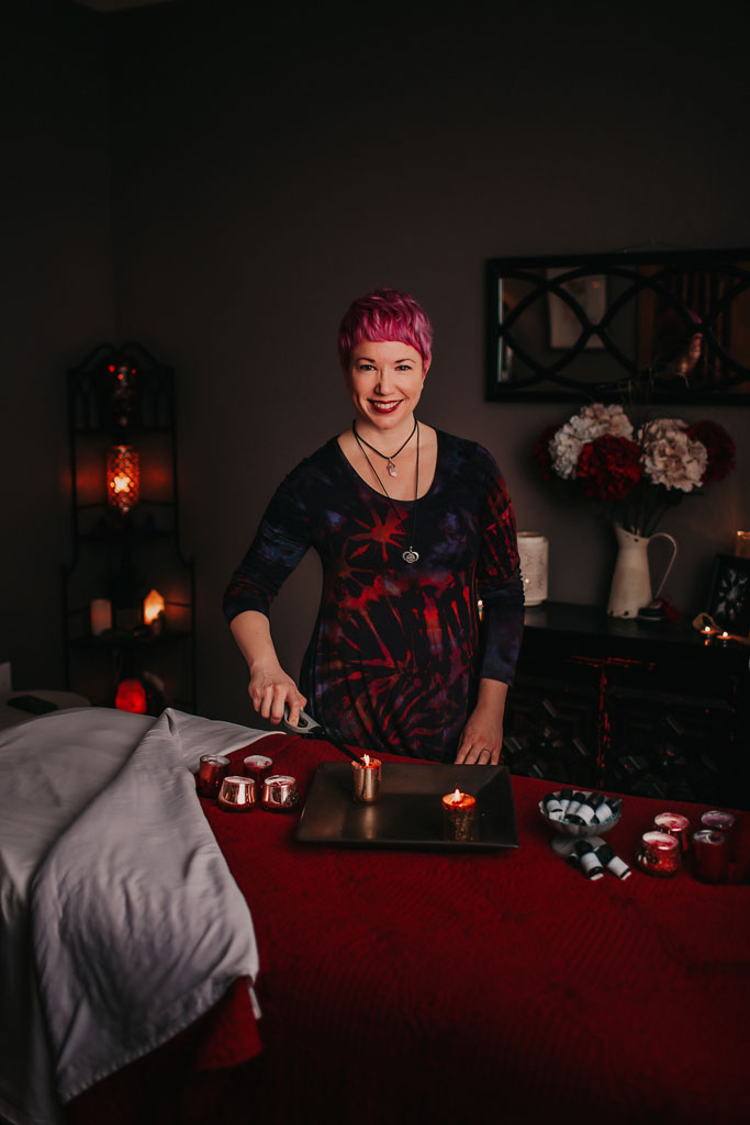 Amber-Parrish-Manager-LMT-Precision-Wellness-looking-up-lighting-a-candle
