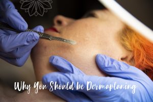 dermaplaning gloved hands with dermaplaning tool