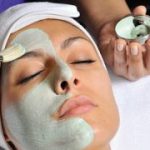 woman's face with clay mask being applied